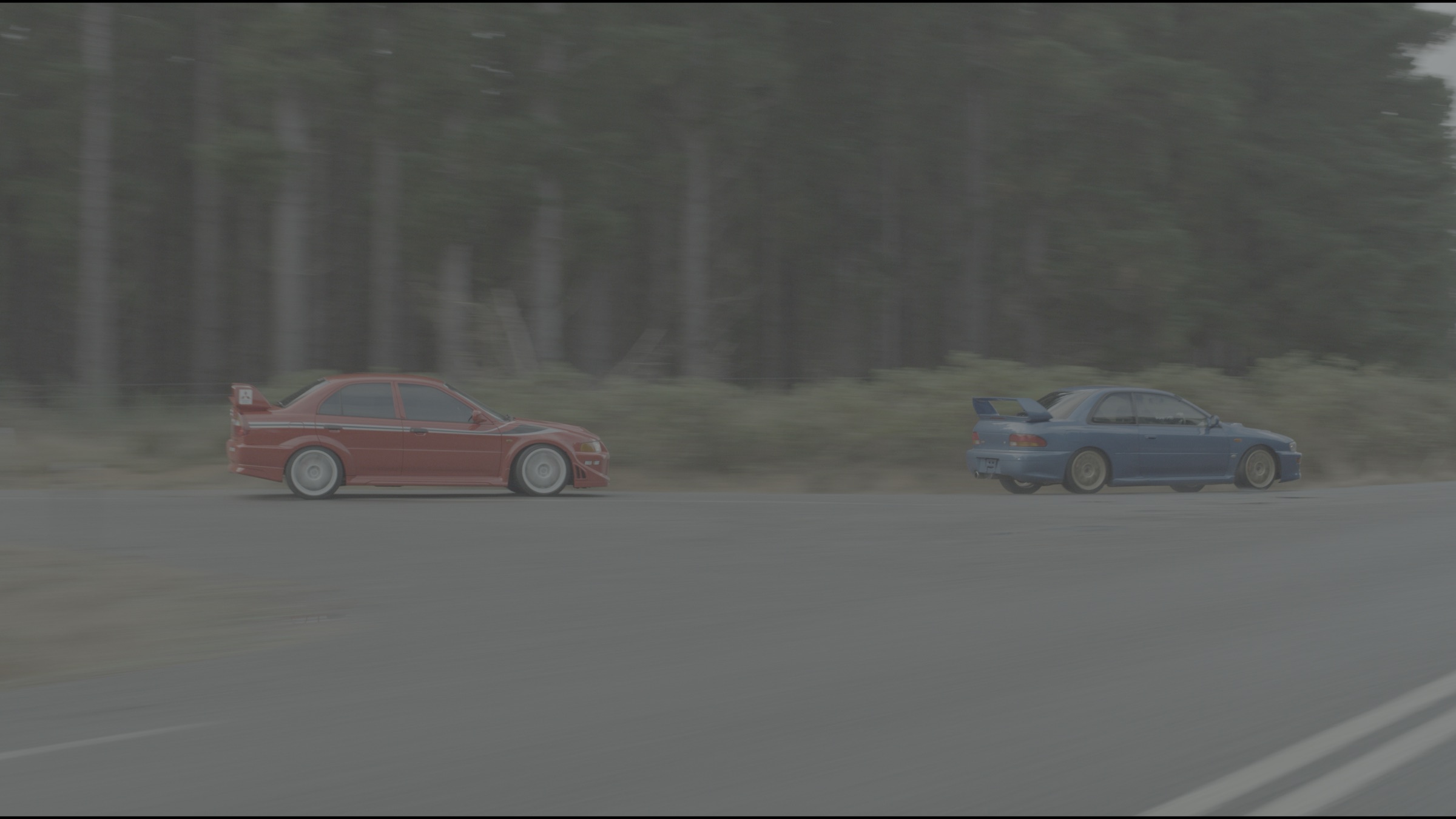 Ungraded log frame of two rally cars on a forest road